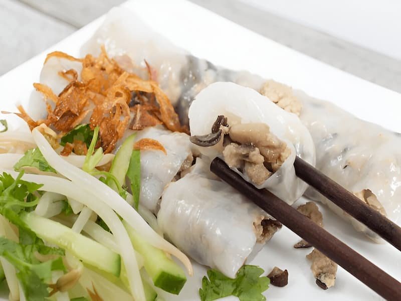 Transparent banh cuon rice rolls showing pork and mushroom filling at a hidden food gem in Hanoi