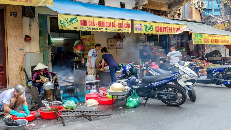 Early morning food preparation at a hidden gem street food stall in Hanoi