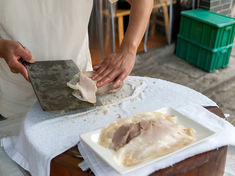 Traditional banh cuon rice roll preparation technique at Ba Hoanh in Hanoi