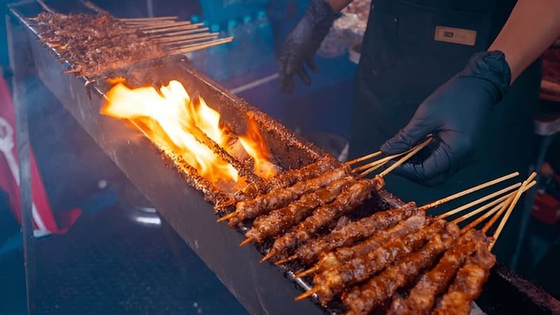 Satay grilling at Lau Pa Sat for the best time to visit Singapore for street food