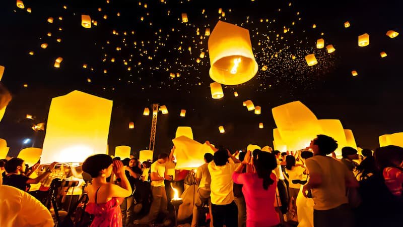 Floating lanterns light up a river during Thailand’s Loy Krathong festival under a night sky in November.