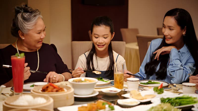 Multi-generational Vietnamese family enjoying street food together in Hanoi