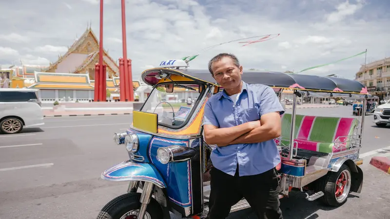 uk-tuk driver talking to tourists on a Bangkok street