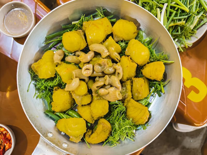 Tableside preparation of cha ca turmeric fish with dill at Cha Ca Thang Long in Hanoi