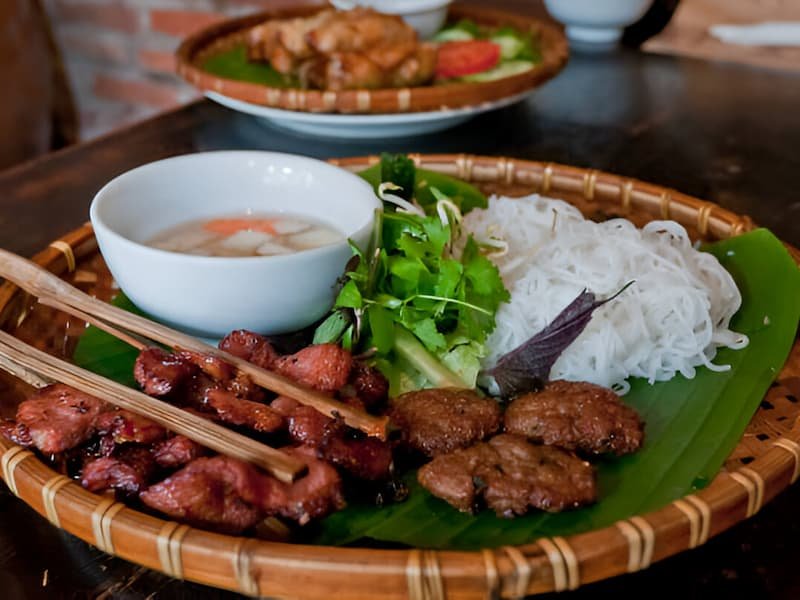 Traditional bún chả with grilled pork, rice noodles, and herbs at Bún Chả Đắc Kim in Hanoi