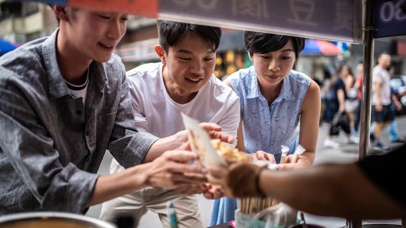 Food tour group exploring street food in Hanoi's Old Quarter with local guide