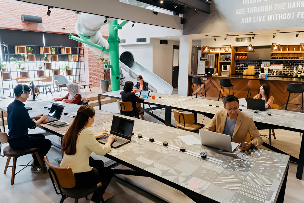 Modern café-style coworking space in Phnom Penh with wooden design elements and hanging lamps, offering affordable workspaces for digital nomads in Cambodia's budget-friendly environment