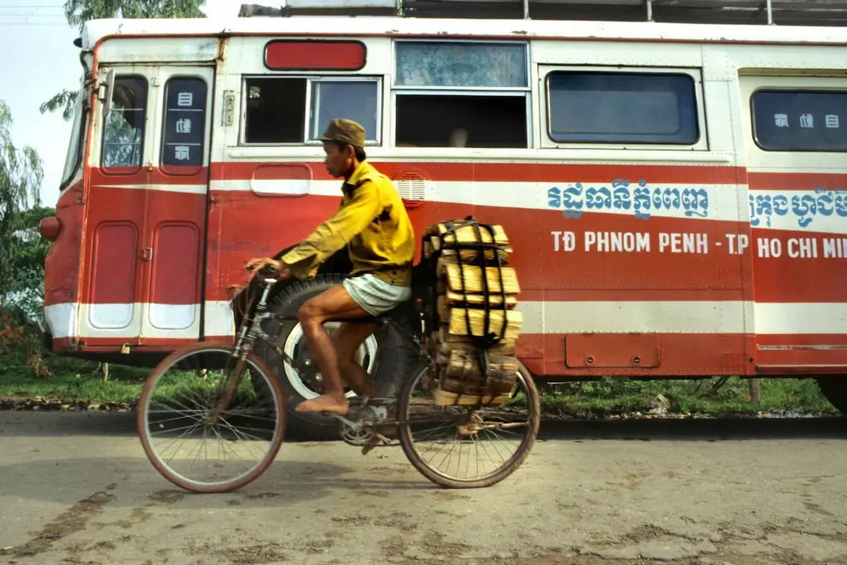 Modern long-distance bus in Cambodia with colourful exterior branding, offering budget travellers intercity transport for $6-12, significantly cheaper than comparable services in Thailand and Vietnam