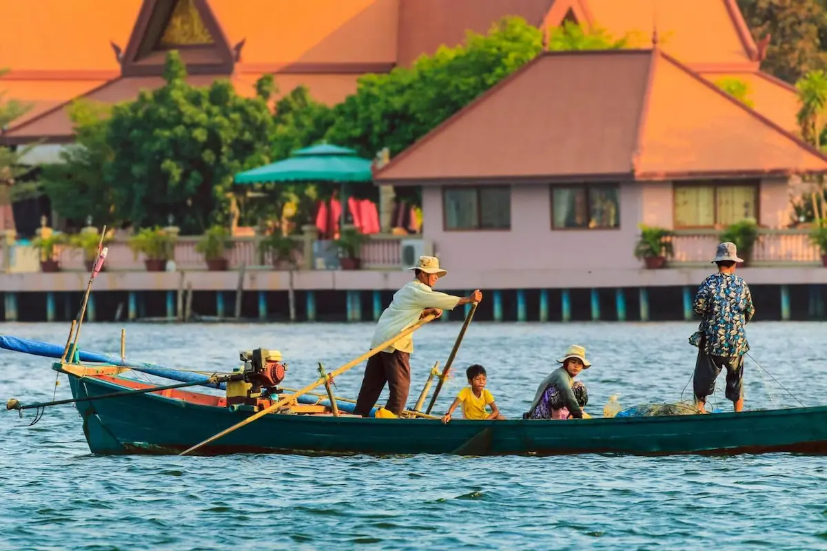 Boat tour on Kampot river with limestone karst backdrop, a popular $8 excursion for budget travelers