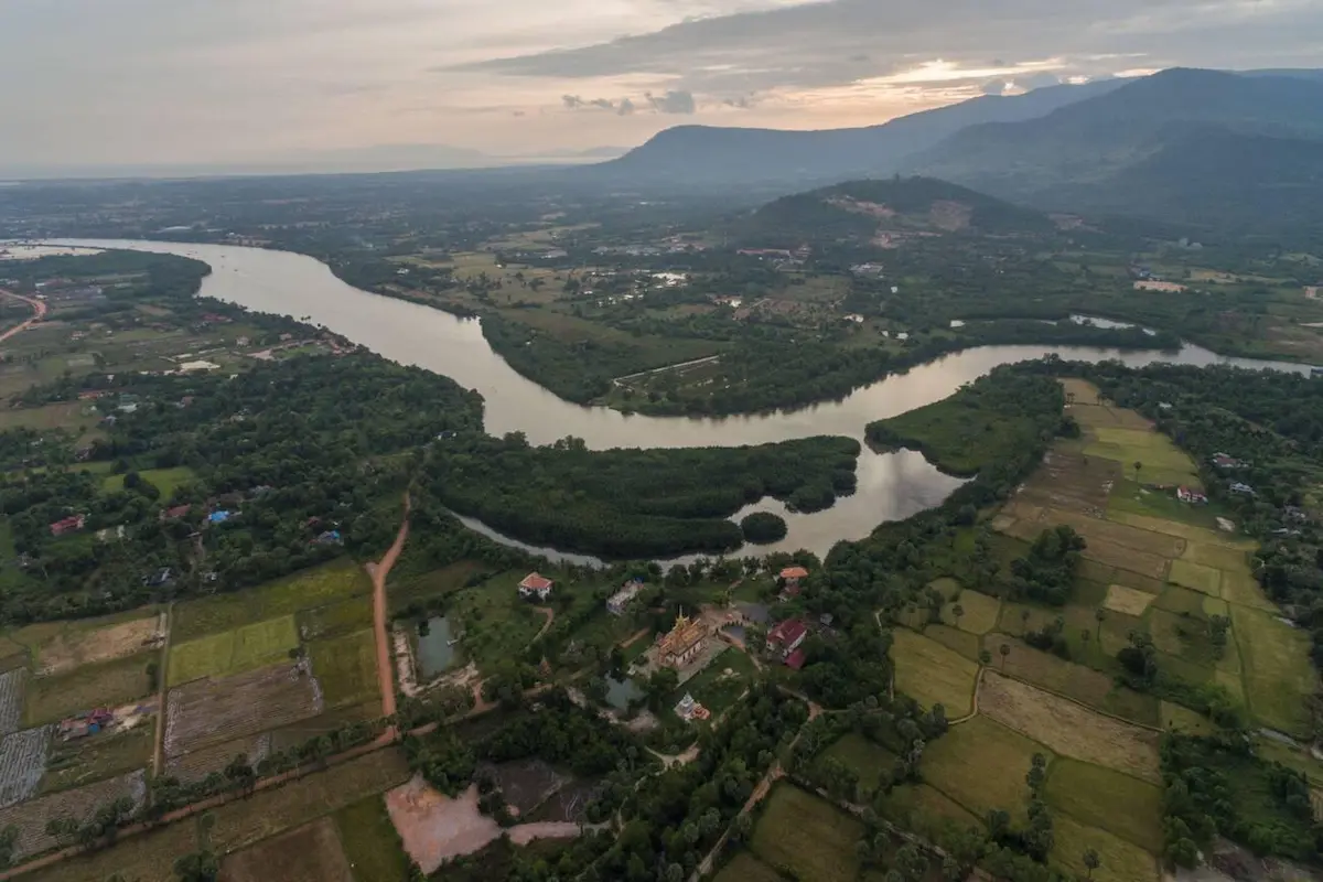 Aerial view of Kampot's lush riverside landscape showing the rural charm that has attracted budget travelers