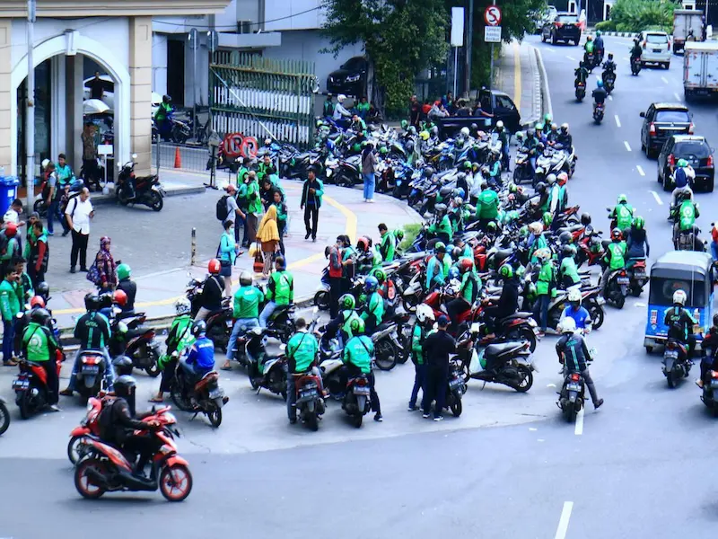 Motorcycle taxi (ojek) drivers waiting for customers in Jakarta traffic