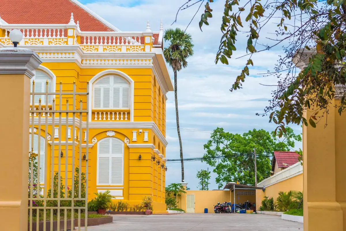 Vibrant yellow French colonial building in Kampot, Cambodia showcasing the well-preserved architecture that budget travelers can explore for free, adding cultural value to this affordable destination