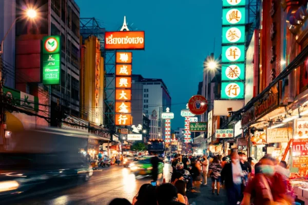 Tourists walking in Bangkok street with caution sign overlay