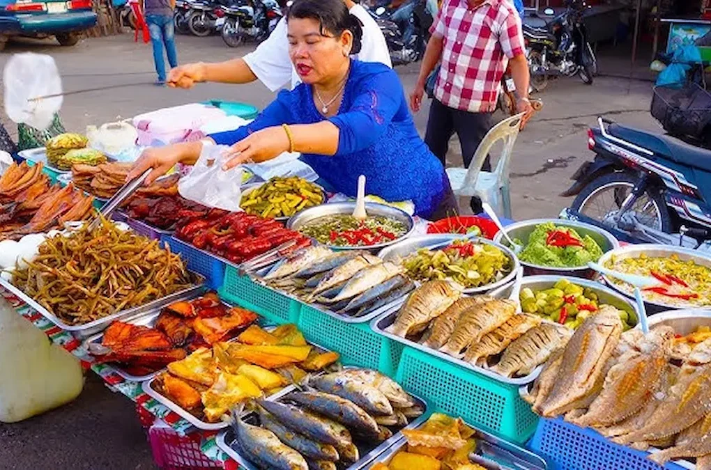 woman serving food at a Cambodian street food market