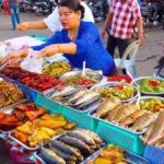 woman serving food at a Cambodian street food market