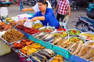 woman serving food at a Cambodian street food market